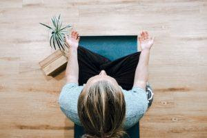 A person sitting on a yoga mat and meditating, which is one of the strategies to help overcome fear and anxiety.