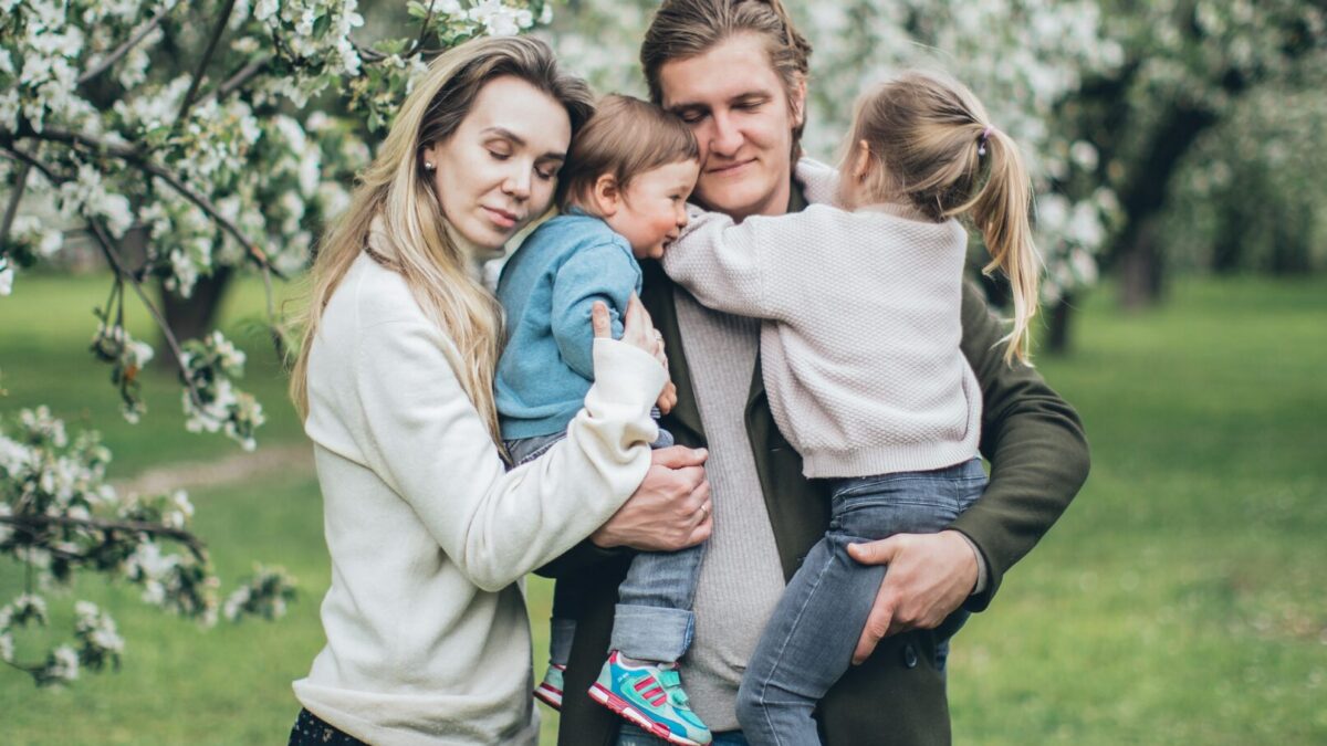 an embraced family of four by a tree dealing with the challenges of dysfunctional families