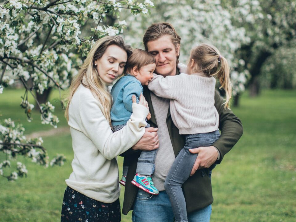 an embraced family of four by a tree dealing with the challenges of dysfunctional families