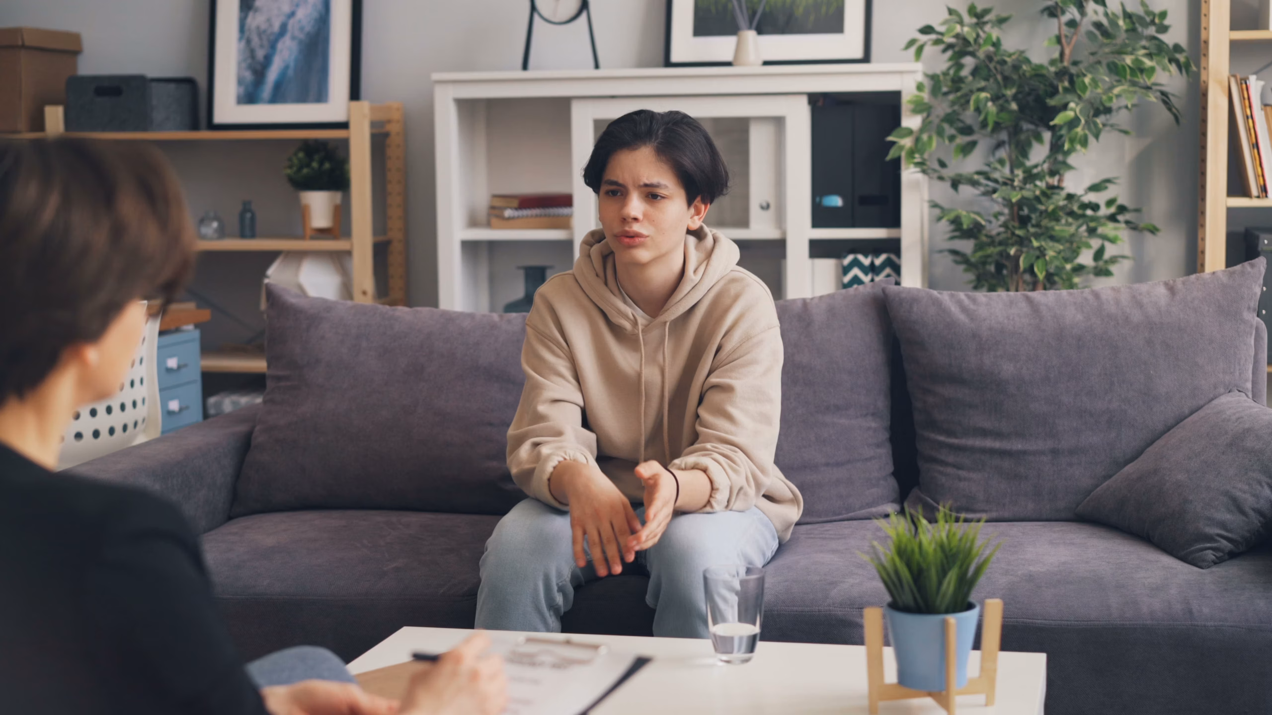 a teenager sitting on a couch during his therapy session
